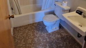 A bathroom with a bathtub, toilet, and sink.