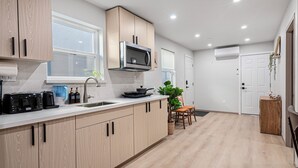 Une cuisine moderne avec des meubles en bois, un four à micro-ondes et un évier.