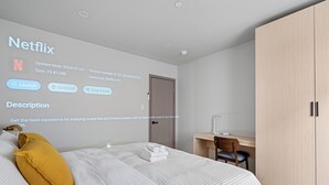 Une chambre d’hôtel moderne avec un lit bien fait, un bureau et une armoire.
