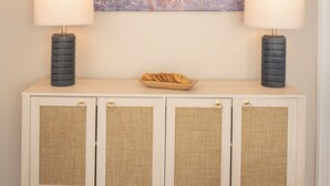 A wooden console table with two lamps, a plate of cookies, and a painting of a bull. - The Bluebonnet - Pet-Friendly Historic 3BR Home in Downtown McKinney (McKinney)