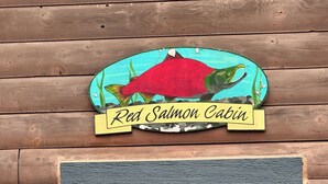 Eine Holzhütte mit einem Schild, auf dem 'Red Salmon Cabin' steht.