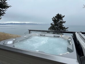 Un jacuzzi con vistas a un lago y montañas.