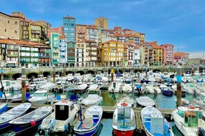 A marina with numerous boats docked, surrounded by colorful buildings with varied architectural styles.