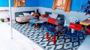 Ein Zimmer mit einem Bett, einem kleinen Tisch, einem Stuhl und einem Sofa.