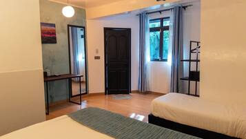 Un dormitorio con cama, escritorio, silla, estante y puerta.