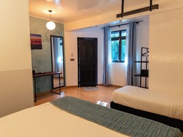 Un dormitorio con cama, escritorio, silla, estante y puerta.