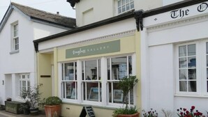 A Seaglass Gallery with large windows and potted plants outside. - The Pepper Pot Sleeps 4 Sunlit Garden (Exmouth)
