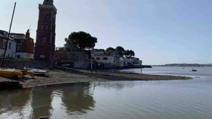 A coastal town with a prominent tower, calm water, and buildings along the shore. - The Pepper Pot Sleeps 4 Sunlit Garden (Exmouth)