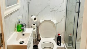 Un baño con inodoro, lavamanos y ducha.
