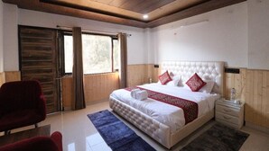 Una camera da letto con un letto grande, soffitto in legno e finestra con tende.