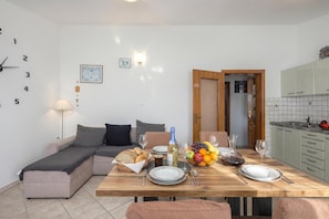 Um espaço de estar moderno com área de jantar, cozinha e sofá.