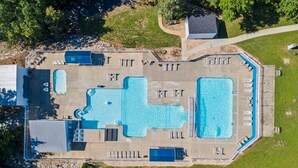 An aerial view of a resort with multiple swimming pools, sun loungers, and a covered area. - Freshly Updated Lake-Access Condo with Outdoor Pool, Mini Golf, Pickleball & Free Attraction Tickets (Kimberling City)