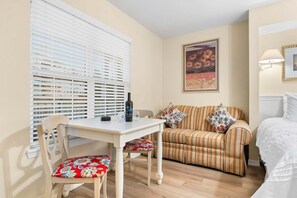 A cozy room with a dining table, a sofa, and a bed.