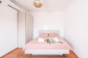 A bedroom with a bed, pillows, a bouquet of flowers, and a magazine on the bed. - Sea Dream Apt /w Sea View Balcony, Lopar, Croatia (Lopar)