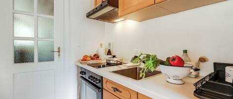 A kitchen with wooden cabinets, a stainless steel sink, and a dish rack.