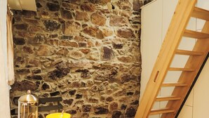 A stone wall, a wooden ladder, and a table with yellow bowls.