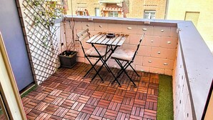 A small patio area with a brick floor, a table and chairs, and a potted plant. - Gorgeous apartment near the metro (Torino)