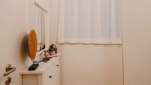 A bathroom with a white vanity, a mirror, and a window with sheer curtains. - Gorgeous apartment near the metro (Torino)