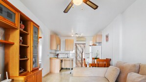 Una sala de estar moderna con un sofá, un mueble de madera y un comedor con mesa y sillas.