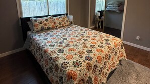 Une chambre à coucher avec un lit, un ventilateur de plafond, une fenêtre et une porte.