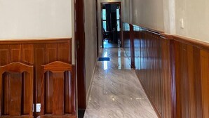 Un pasillo con paneles de madera en las paredes y suelo de mármol.