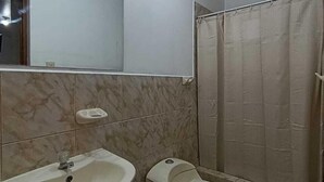 A bathroom with a sink, toilet, and shower curtain.
