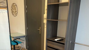 Une chambre à coucher avec un lit, une armoire et un bureau.