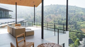 Un interno moderno con ringhiera in vetro che si affaccia su un paesaggio lussureggiante.