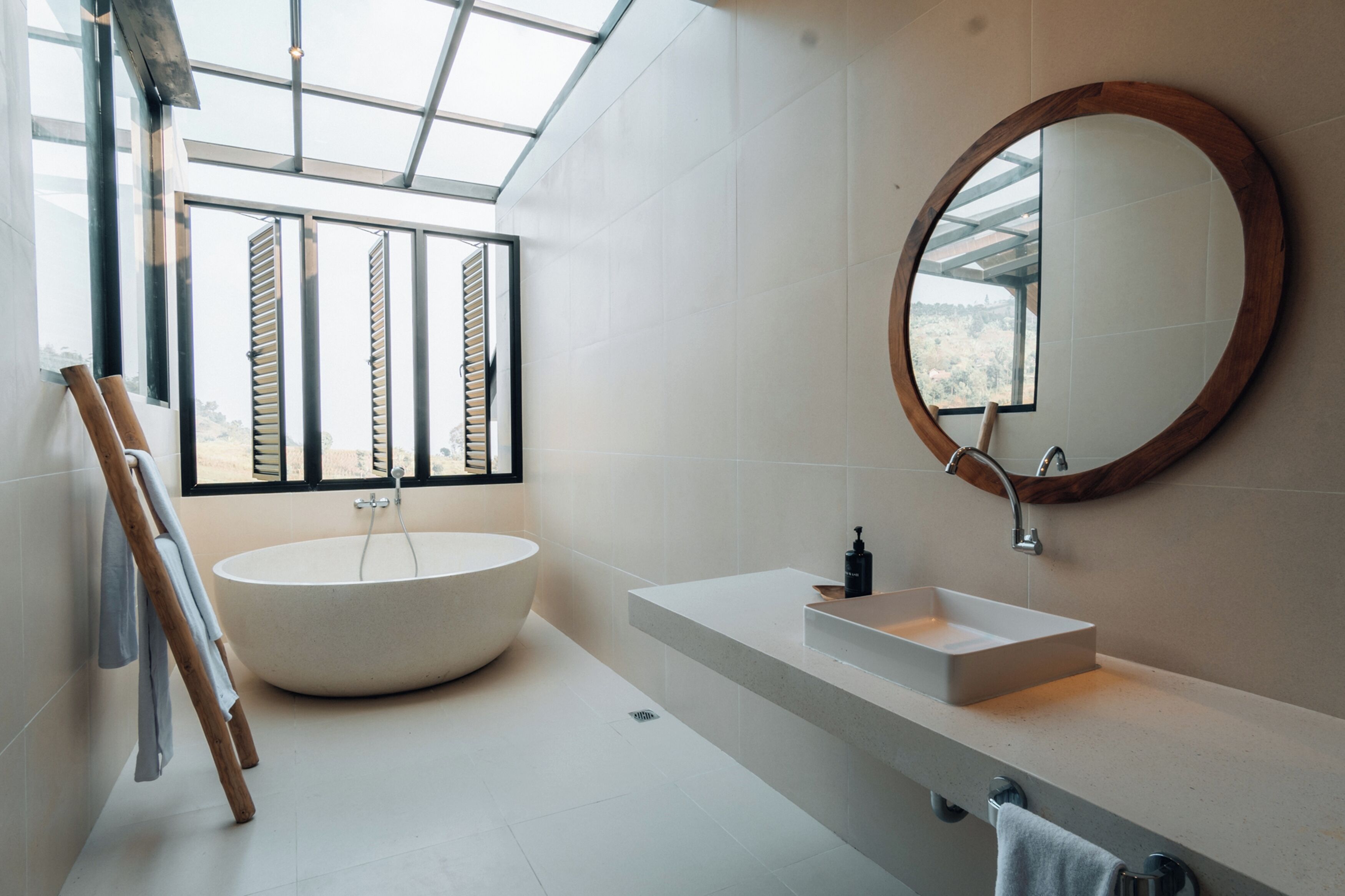A modern bathroom with a freestanding bathtub, a rectangular sink, and a large mirror.