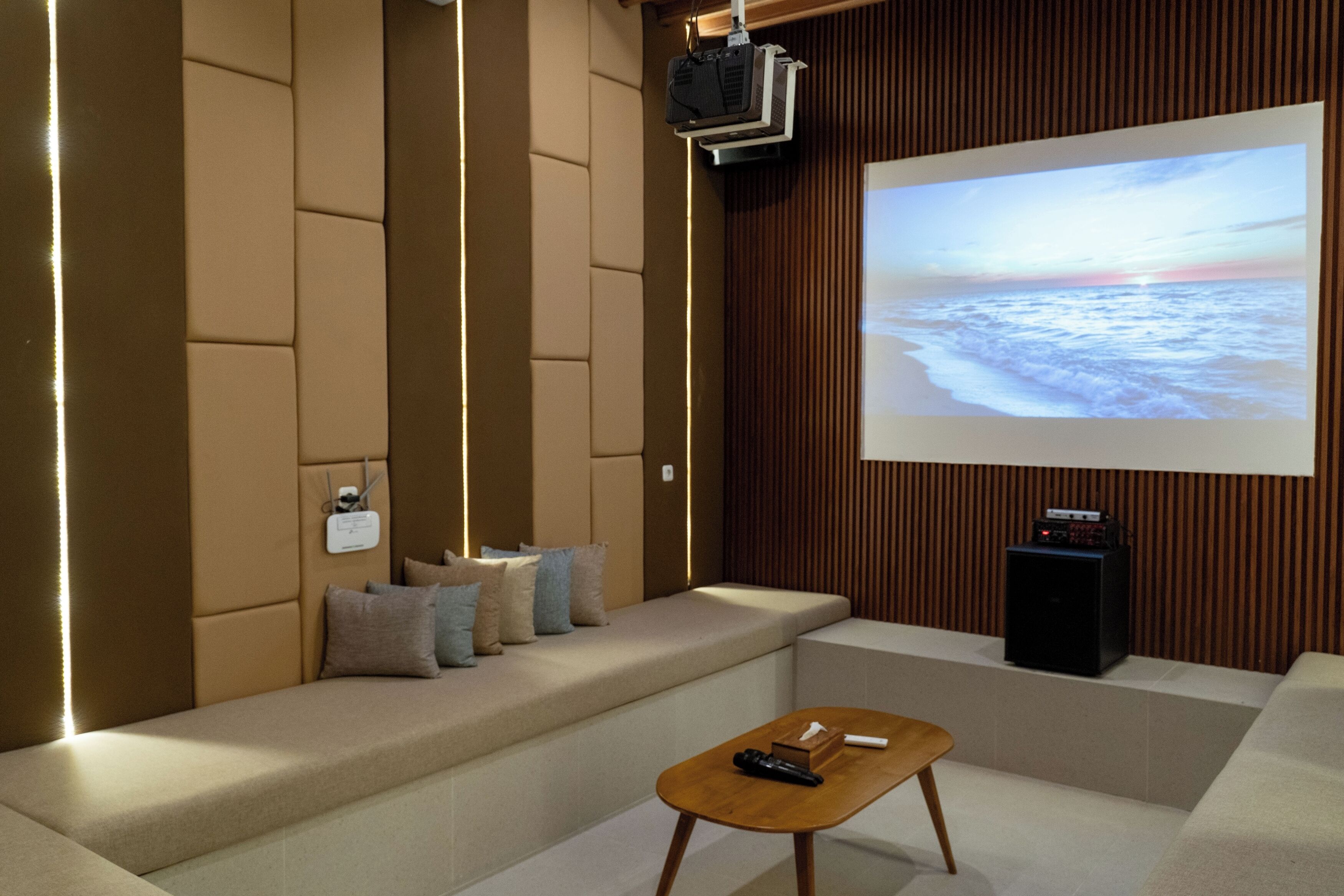 Una sala de estar moderna con una pantalla grande, asientos cómodos y una pared de acento de madera.