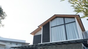 Un edificio moderno con un'ampia finestra, un balcone e una porta ben visibile.