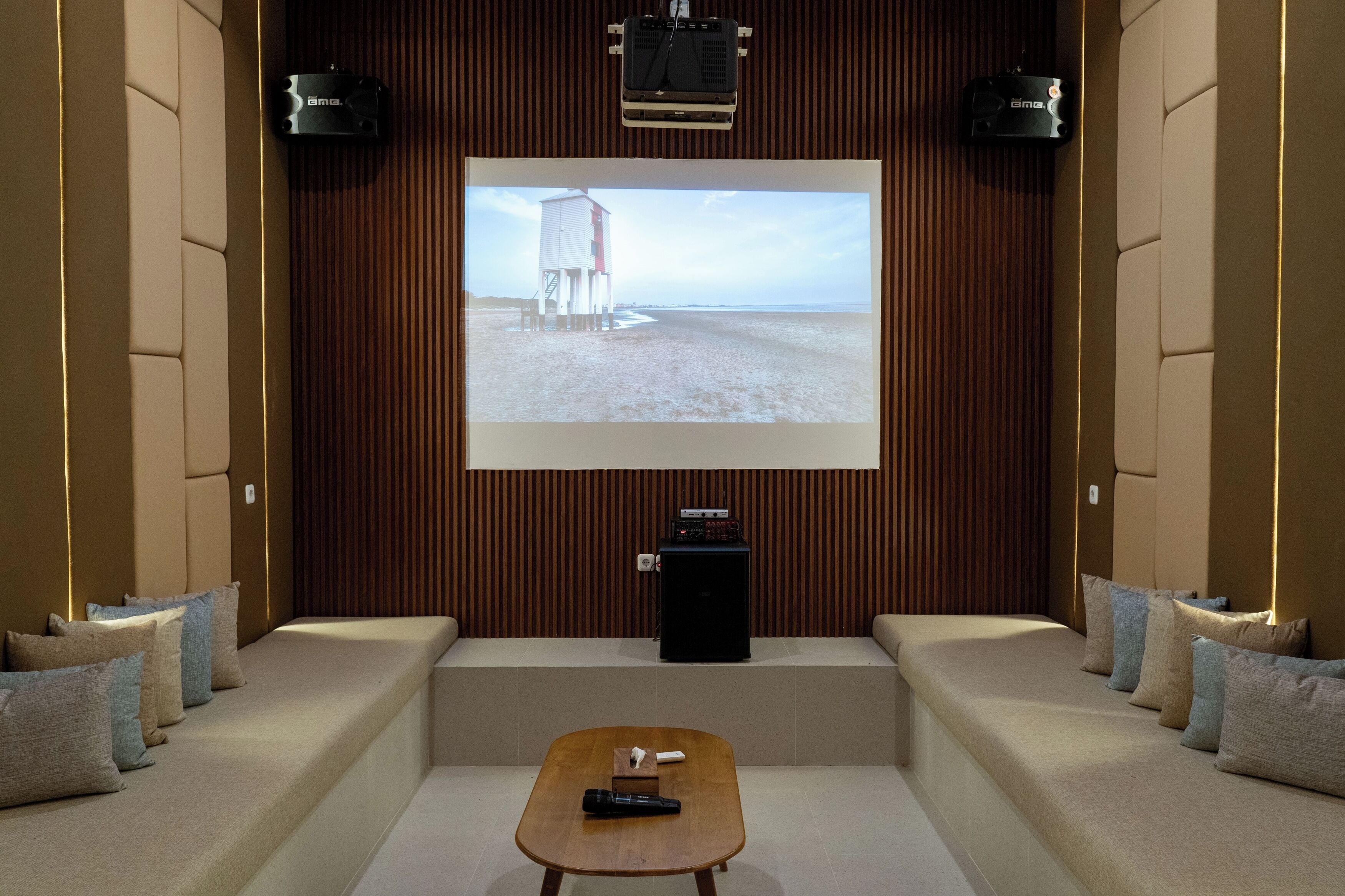 A home theater with a large screen, comfortable seating, and a coffee table.