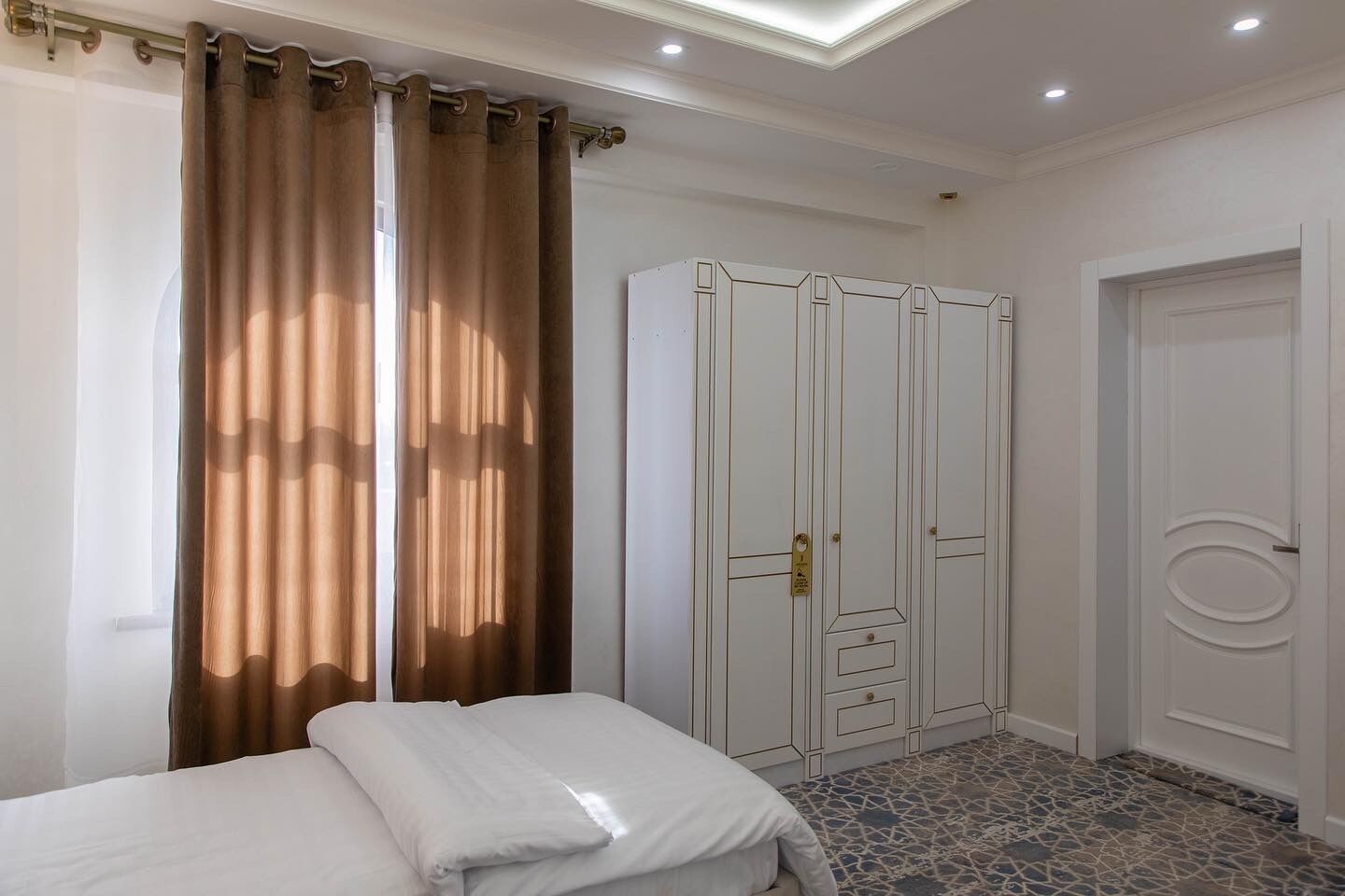 Un dormitorio con una cama, un armario y una puerta.
