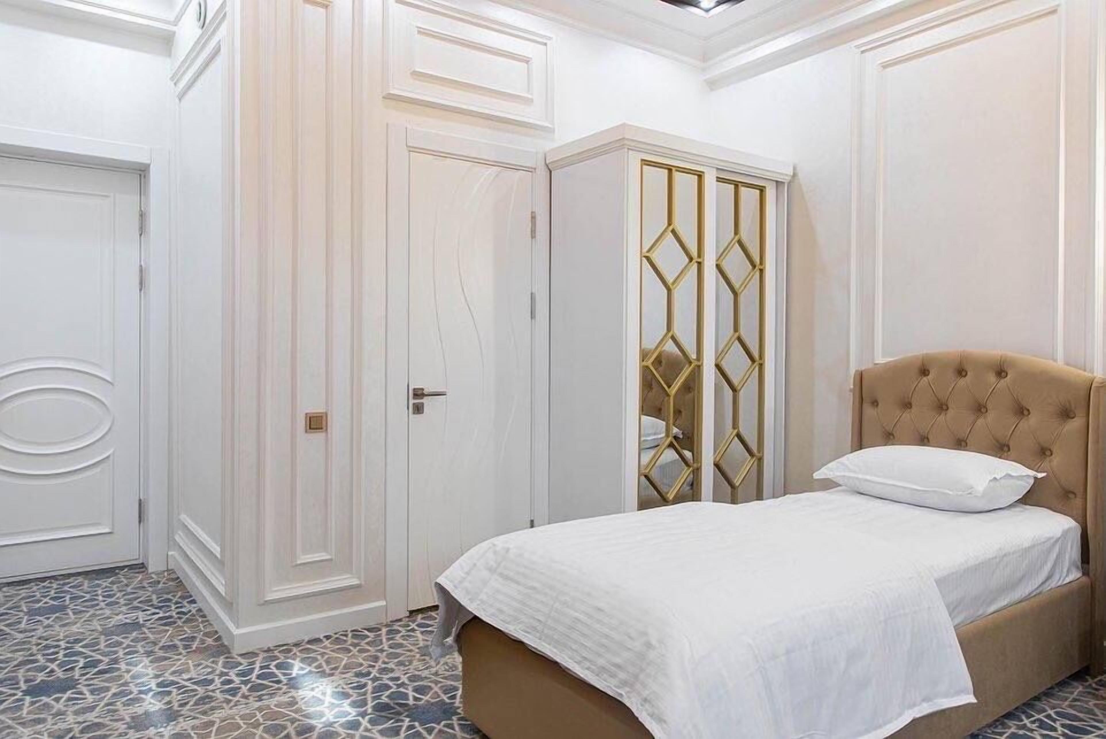 A bedroom with a bed, a wardrobe, and a door.