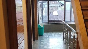 Un pasillo con paredes de madera y piso de baldosas que conduce a una escalera.