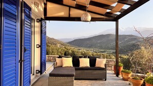 A covered outdoor seating area with a view of a mountainous landscape. - Villa Francesca, Greek Garden Getaway in Agia Galini (Agia Galini)