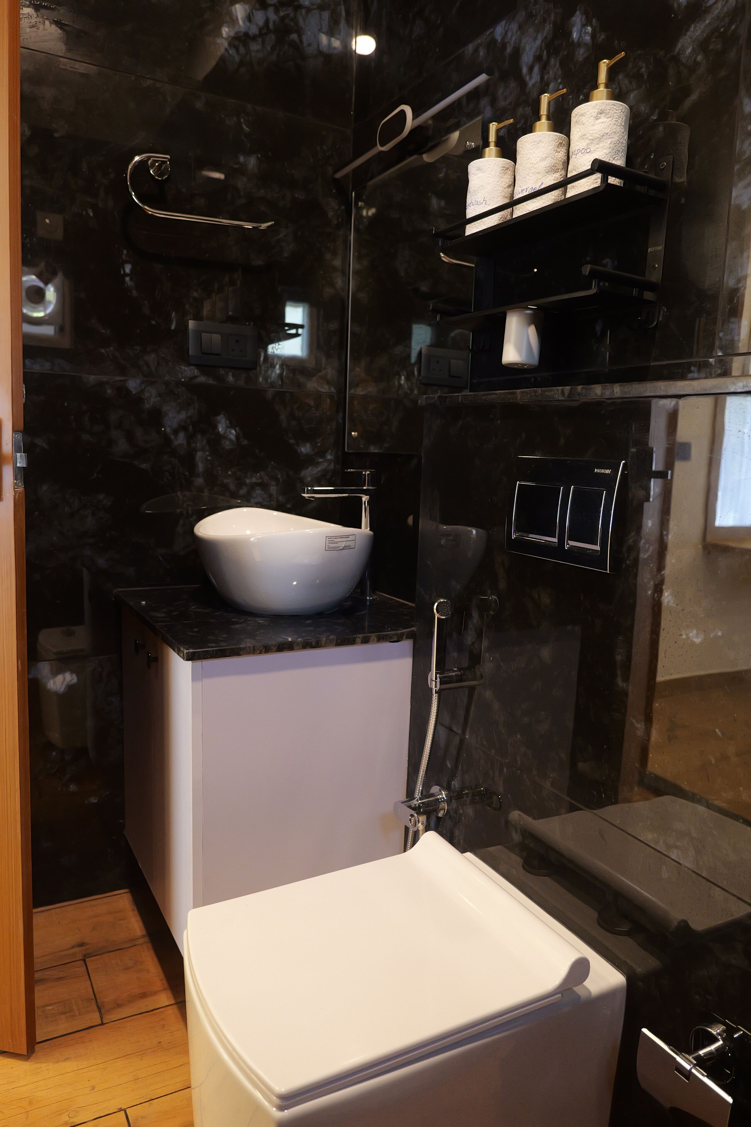 A compact bathroom with a white sink, a toilet, and a shower area.
