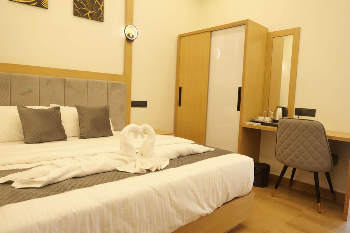 Hotellihuone, jossa on sänky, työpöytä, tuoli ja vaatekaappi.