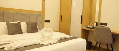 A hotel room with a bed, a desk, a chair, and a wardrobe.