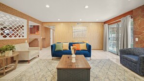 A spacious living area with a blue sofa, a wooden coffee table, and a patterned rug. - 5 BR Jacuzzi 12 Mins to Disney Knotts Beach (Norwalk)