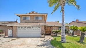 A two-story house with a garage, palm trees, and a well-maintained lawn. - 5 BR Jacuzzi 12 Mins to Disney Knotts Beach (Norwalk)