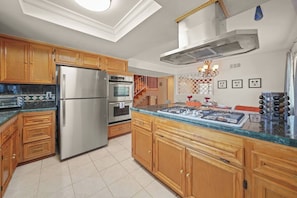 A modern kitchen with wooden cabinets, stainless steel appliances, and a skylight. - 5 BR Jacuzzi Disney Knotts Beach (Norwalk)