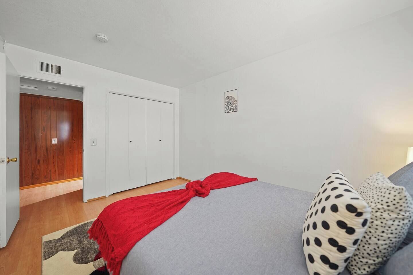 Un dormitorio con cama, armario y puerta.