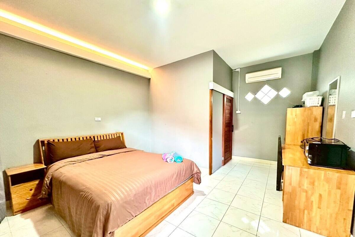 A bedroom with a bed, bedside table, wardrobe, and a door.