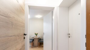 Un couloir doté d’un plancher en bois, de murs blancs et de deux portes numérotées 9 et 10.