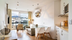 A modern apartment with a dining area, kitchen, and a large window with a city view. - Golden escape in Funchal (Funchal)