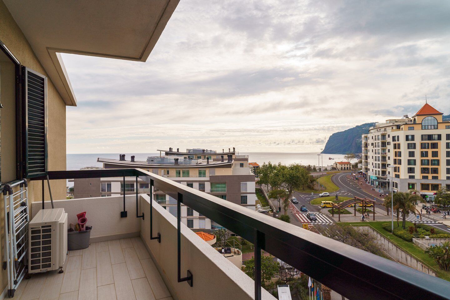 Un balcon avec vue sur la mer et une route.