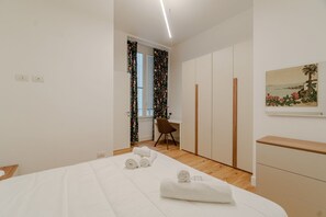 Escritorio, tabla de planchar con plancha, internet y ropa de cama