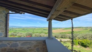 A stone wall with a view of a green landscape under a wooden roof structure. - Cosy and roomy apartment of 110 sqm for 6 persons on the 1st floor of a rustic-style farmhouse (NO lift or stairs for access), immersed in the Umbrian countryside.The accommodation consists of a kitchen, a living room, three bedrooms, two bathrooms and t (Castiglione del Lago)