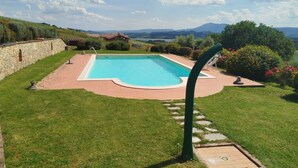 A swimming pool with a view of mountains and a stone wall. - Cosy and roomy apartment of 110 sqm for 6 persons on the 1st floor of a rustic-style farmhouse (NO lift or stairs for access), immersed in the Umbrian countryside.The accommodation consists of a kitchen, a living room, three bedrooms, two bathrooms and t (Castiglione del Lago)